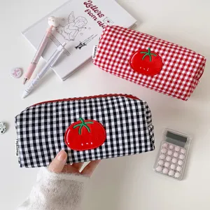 Detail view of Korean style red and black checkered pencil cases with tomato embroidery
