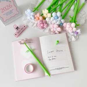 Detailed view of colorful fabric flower pen on a notebook with aesthetic desk accessories