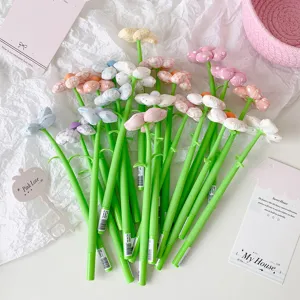 Close-up of decorative fabric flower gel pens with colorful plush toppers and green stems