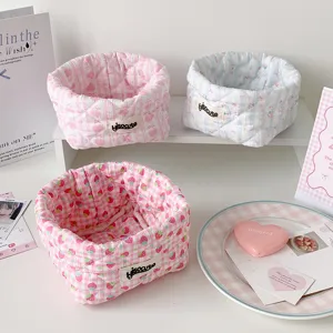 Macro view of three quilted fabric storage baskets with cute patterns and hisocute labels.