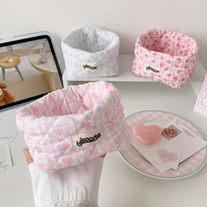 Detailed view of a cute pink fabric storage basket with bow patterns for desk organization
