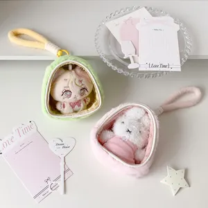 Detailed view of plush doll display bags in green and pink with cute charms