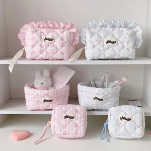 Detailed close-up showing pink and blue quilted fabric storage bags and desk bins