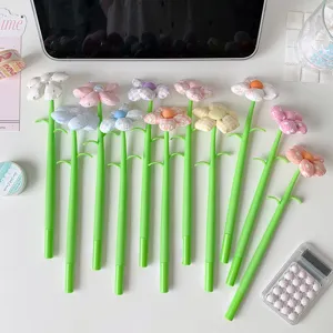 Close-up of colorful fabric flower gel pens arranged on a desk with cute stationery props.