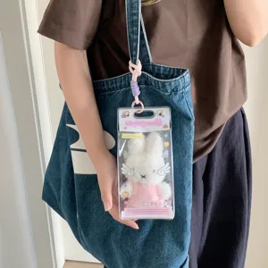 Detail of 10cm clear PVC display bag for cotton dolls hanging on a denim tote bag