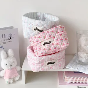 Close-up of three stacked quilted fabric storage baskets for desktop organization
