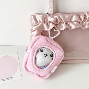 Detail of a pink polka dot plush doll storage bag with a transparent display window