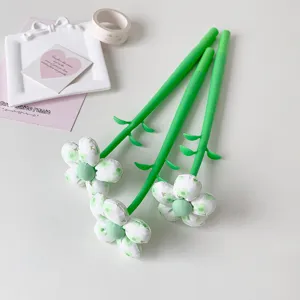 Aesthetic detail of cute green fabric flower neutral pens with leaf-shaped stems