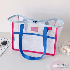 Primer plano de un bolso de malla de gran capacidad con asas coloridas y detalle