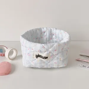Detailed view of the quilted light blue striped storage basket with cute bow pattern