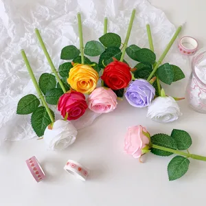 Detailed view of colorful artificial rose ballpoint pens on white crinkled paper