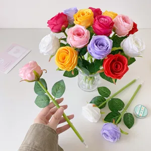 Detail showing colorful artificial rose-shaped ballpoint pens with realistic silk petals