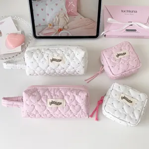 Vue détaillée de trousses à motifs de cœurs matelassés en rose et blanc, mignon