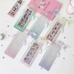 Detailed view of six pastel glittery angel wing card sleeves for photobooth strips on a desk