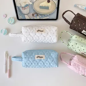 Vue détaillée de plusieurs trousses matelassées à pois élégantes dans des couleurs pastel