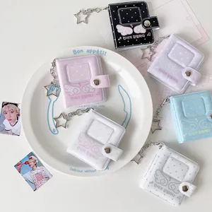 Detalle de mini álbumes de fotos de PVC de colores con colgantes de estrella y alas