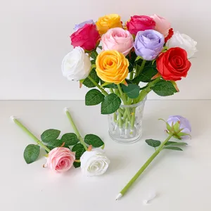 Detailed shot of assorted simulated rose pens in a glass vase and on a flat surface