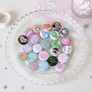 Macro detail of various 25mm mini cartoon badges with cute patterns on a tray
