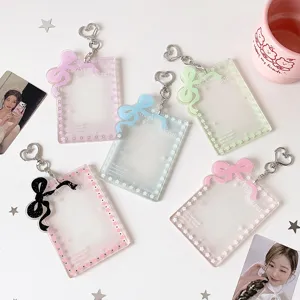 Portacarte per fotocard in acrilico con fiocchi colorati e portachiavi a cuore su bianco