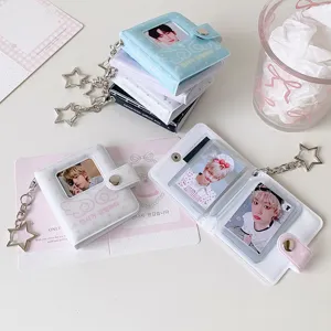 Primer plano de mini álbum de fotos con diseño de alas de ángel y llavero de estrella