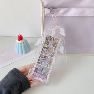 Detailed close-up of a clear acrylic four-cut photo card holder with cute pink angel wings