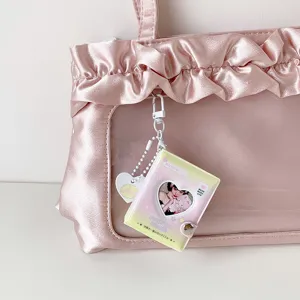 Vista detallada de un mini portafotos de corazón en un bolso rosa con volantes