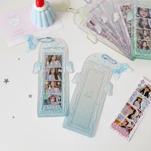 Detail view of glitter angel wing acrylic card sleeves with 4-cut idol photos and blue chains.