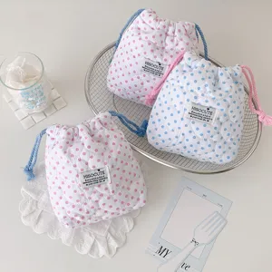 Detalle de bolsas de almacenamiento acolchadas con lunares y cordón en rosa y azul