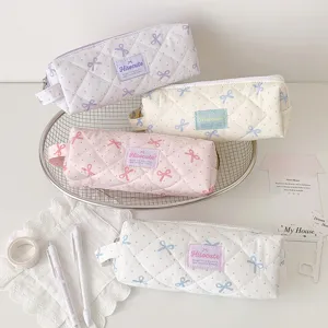 Vue détaillée de trousses matelassées à pois et nœuds mignons aux couleurs pastel.