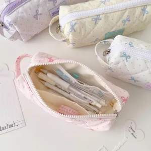 Vue détaillée des compartiments de la trousse rose matelassée avec stylos et washi tape