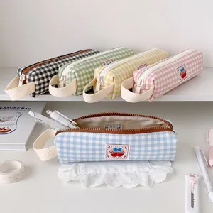 Vari colori di astucci a quadretti in stile coreano esposti con accessori di cancelleria