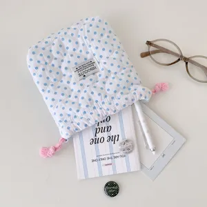 Primer plano de la bolsa acolchada con lunares azules y accesorios de mesa