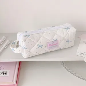 Vue détaillée d'une trousse matelassée avec des motifs de nœuds bleus et pois