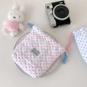 Detalle de la bolsa acolchada con lunares para guardar la cámara Instax en rosa y azul