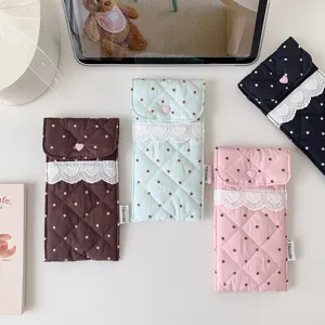 Close-up of quilted storage pouches featuring polka dots, lace trim, and heart buttons