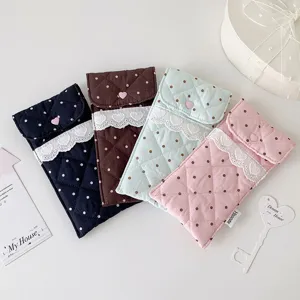 Detailed view of quilted polka dot stationery pouches with lace and heart buttons
