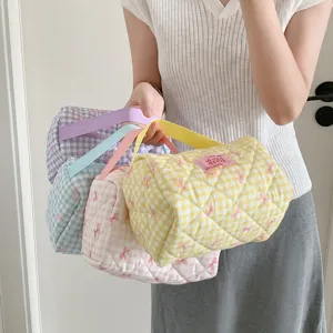 Detailoverzicht van pastelkleurige geruite make-uptassen met strikpatronen en handvaten.