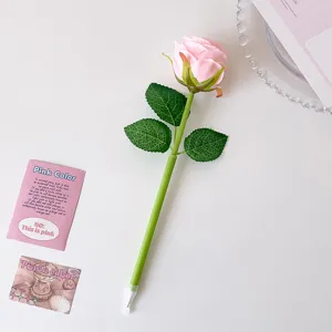 Close-up of a realistic pink artificial rose pen on a white surface with decorative props.