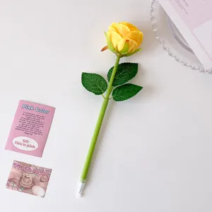 Detailed view of a realistic yellow rose shaped ballpoint pen on white desk background
