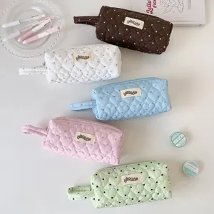 Vue détaillée de cinq trousses à pois matelassées en forme de cœur, couleurs pastel