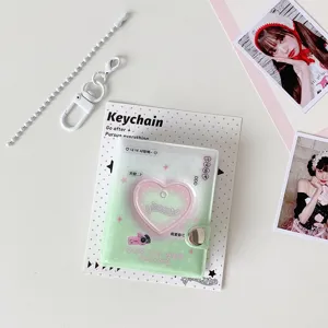 Detalle de mini álbum de fotos en forma de corazón con cadena blanca y llavero