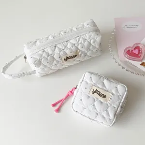 Détail de pochettes matelassées blanches avec motifs de cœurs et pois élégants