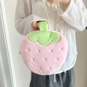 Close-up of a cute pink plush strawberry-shaped cosmetic bag held by a person's hand.
