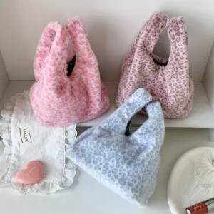 Three plush leopard print handbags in pink, mauve, and blue fuzzy faux fur material.