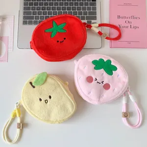 Close-up of cute plush fruit-shaped storage bags in strawberry and tomato designs
