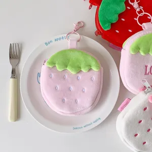 Close-up detail of a cute plush strawberry-shaped coin purse and earphone pouch