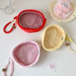 Close-up of colorful plush doll display bags with clear windows and braided handles