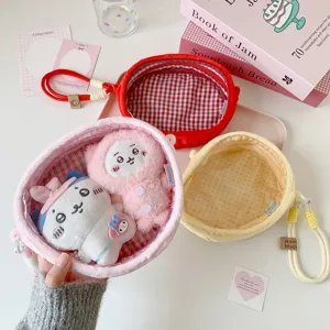 Close-up of cute cartoon plush doll storage bags shown in pink, red, and yellow colors