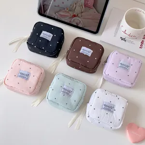 Detalle de varias bolsas organizadoras de lunares de colores para cosméticos y accesorios