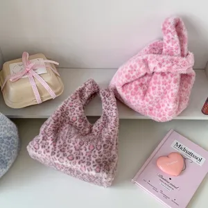 Detail view of plush leopard print handbags in pink and dusty rose colors